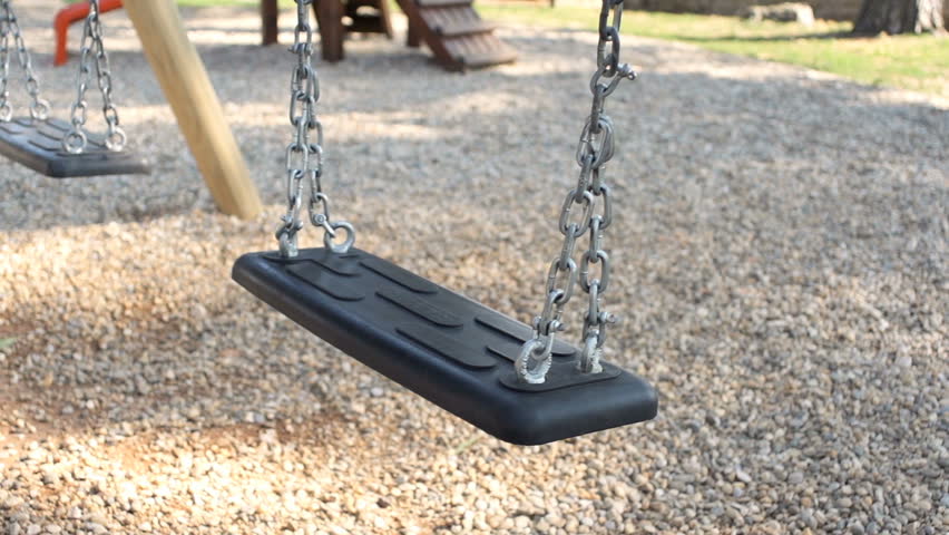 Slow Motion Shot Of An Empty Swing Swinging In The Park