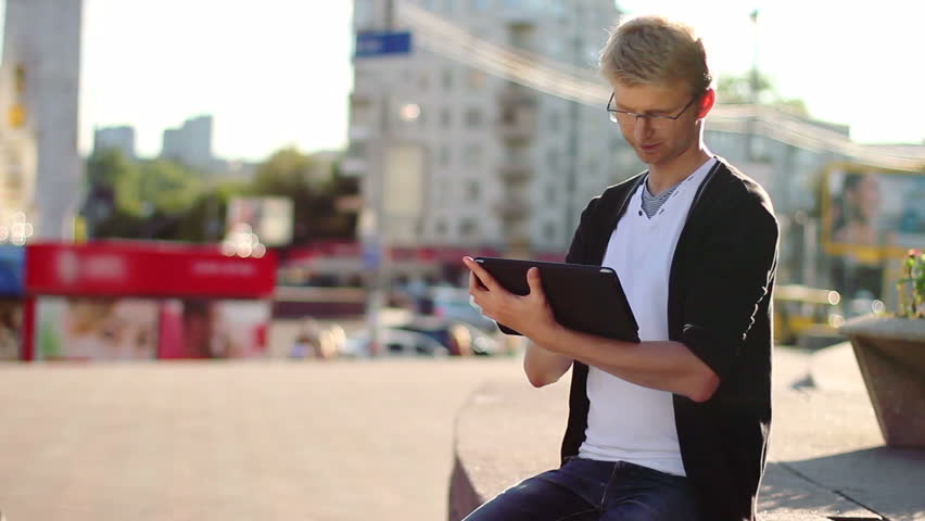 Man reading tablet pad writing browsing photos, looking camera