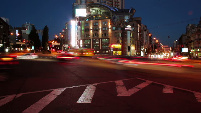 Dusk to night timelapse of cars on city square crossroad, lights