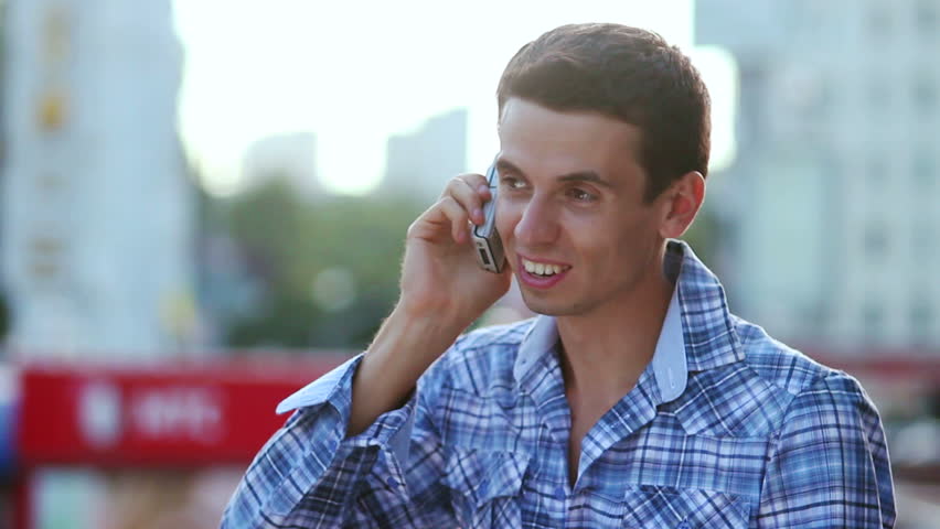 Man talking over phone smiling enjoying call conversation, city