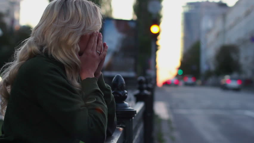 Woman hands on face cries for broken relationships, traffic cars