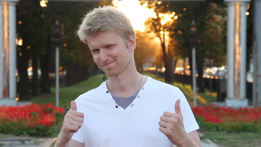 Two thumbs up, confident move by blond haired young adult male