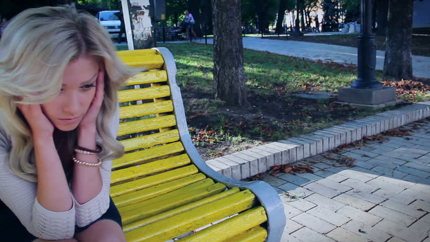 Dolly shot depressed beautiful woman in park, crying broken date