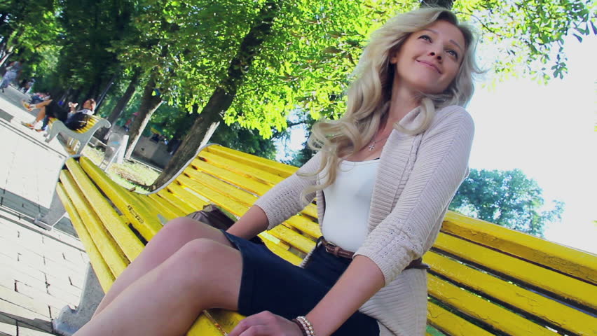 Enjoying smiling young beautiful young female in park bench