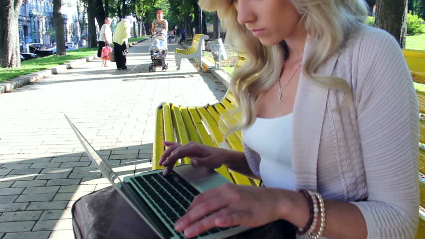Pan tilt young woman with laptop in park, social network, typing