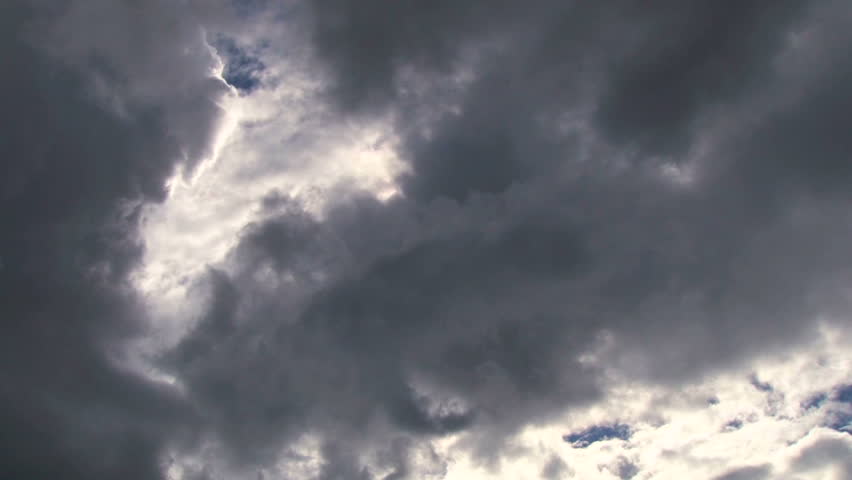 Time lapse during cloudy day with sun shining bright. Storm cloud overtakes sun.