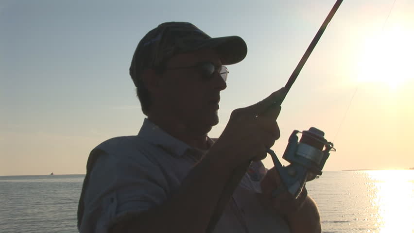 Saltwater Fisherman fishing in Gulf of Mexico for Redfish at sunset.