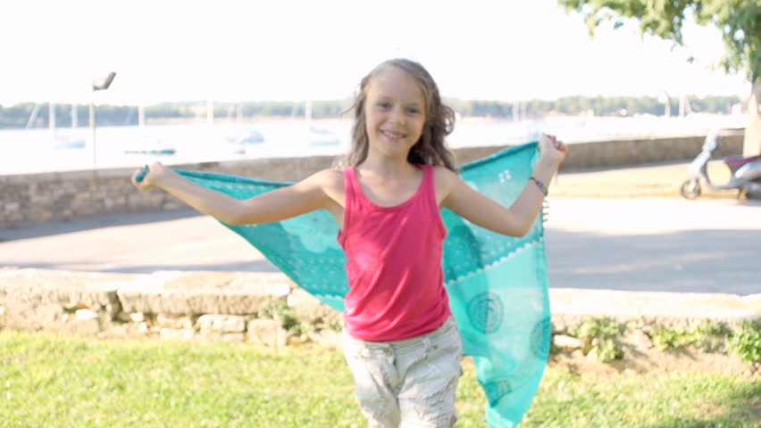 Slow Motion Shot Of A Cute Little Wrapping Herself In A Turquoise Scarf. Looks