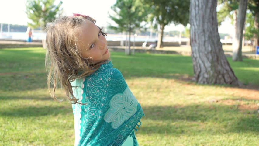Slow Motion Shot Of A Cute Girl Wrapped In A Turquoise Scarf. She Turnes To