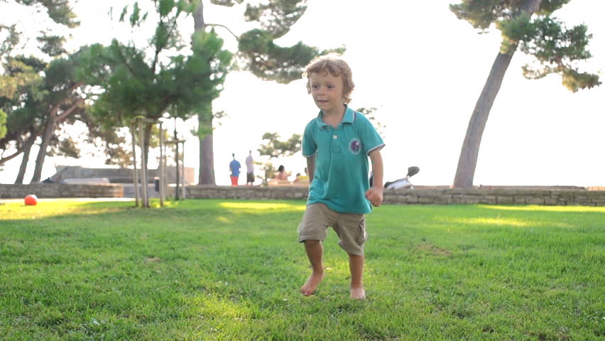 Slow Motion Shot Of A Cute Boy Skillfully Kicking Soccer Ball Into The Camera.
