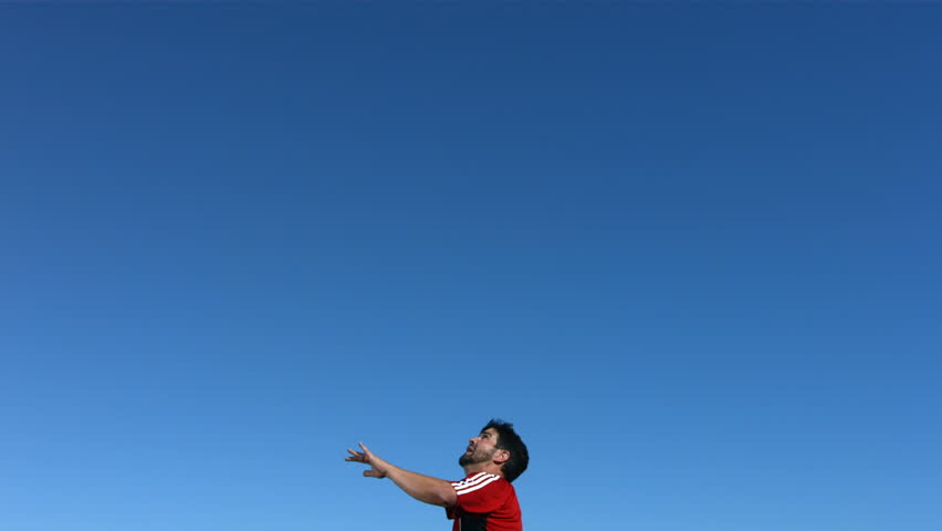 Soccer player kicking ball in mid-air, slow motion