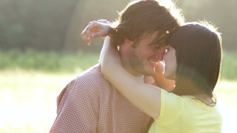 Beautiful Young Couple in Love kissing in a field in slow motion