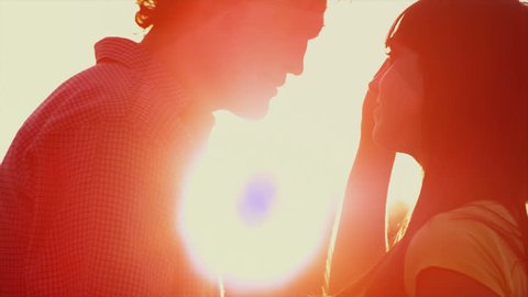 Beautiful Young Couple in Love kiss in a silhouette