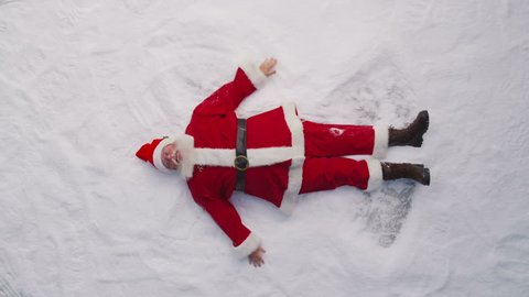 High angle shot of Santa Claus making a snow angel