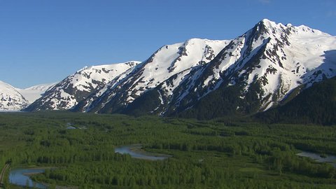 Aerial shot of forest streams and snowy mountains, Alaska