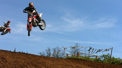 Motocross racers fly over jump, slow motion 库存视频