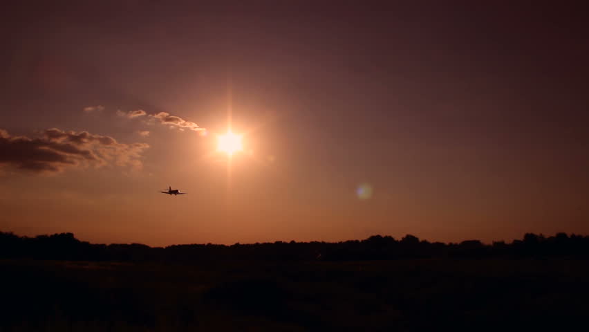 Dusk, airplane flying at sunset, silhouette warm. Business, success, traveling