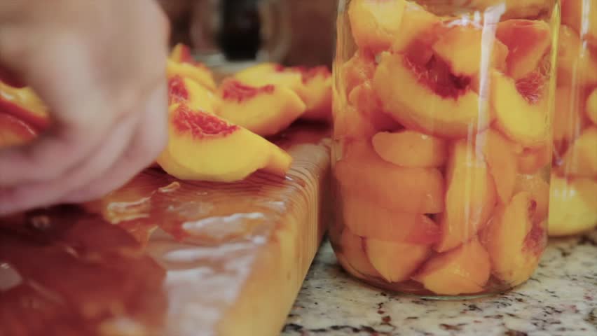 Slicing and skinning peaches for canning.
