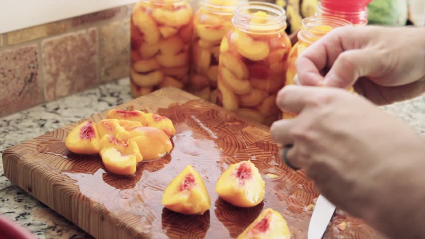 Slicing and skinning peaches for canning.