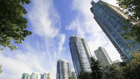 Highrise Condominium Buildings in Downtown Vancouver BC Canada with Moving White Clouds and Blue Sky Time Lapse 1920x1080