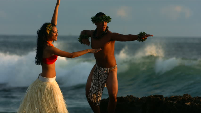 Polynesian dancers perform by ocean, slow motion