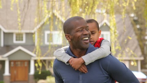 Portrait of African American father and son outdoors in yard: stockvideo
