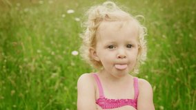 A funny little girl makes various faces at the camera. Close up shot