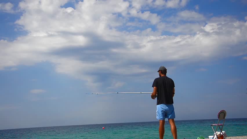 Fly-Fishing at ocean horizon. Fisherman throws fishing tackles doing
