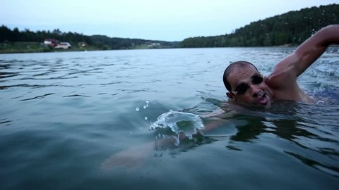 Young man swimming crawl in the lake