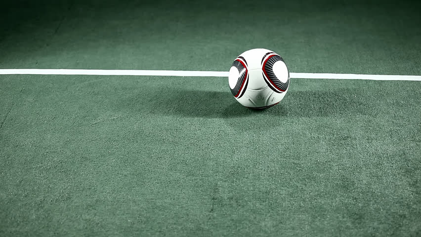 Portrait of an ethnic soccer player picking up ball. Medium shot.