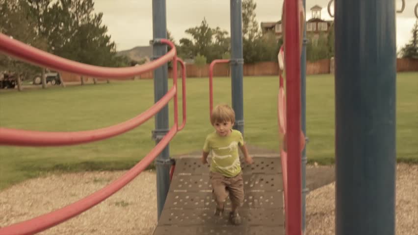 a boy playing at the park on the playground