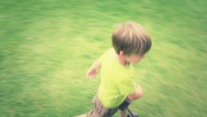 A little boy running on the grass at the park