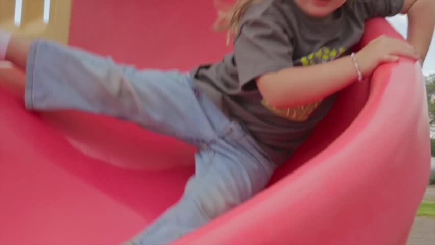 A little girl on the slide at the park