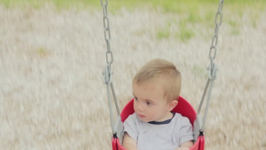 A little boy on the swings at the park