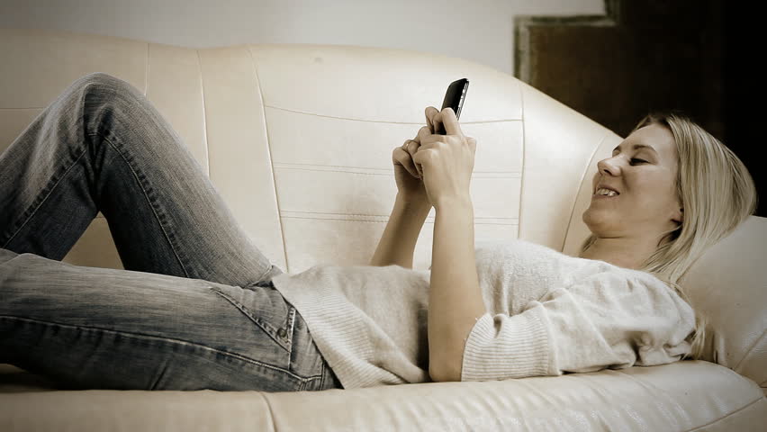 Beautiful girl on sofa with phone