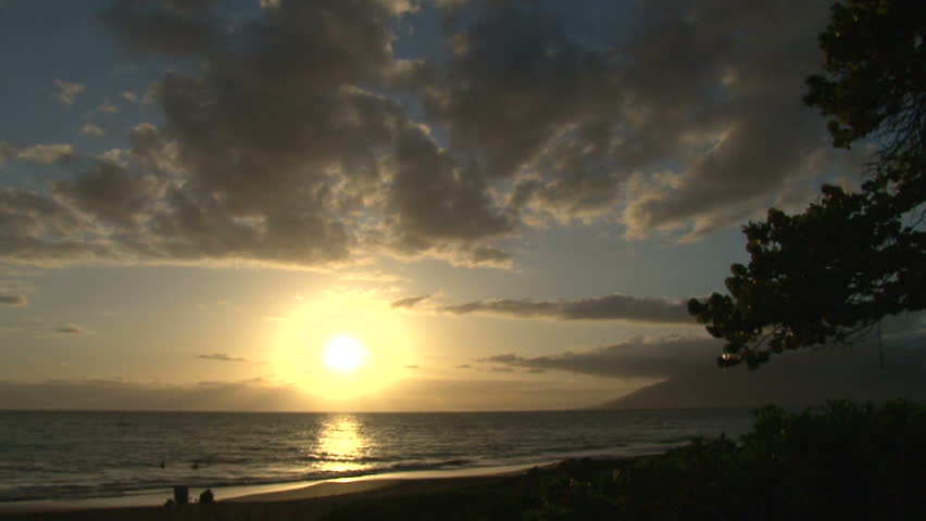 Waves crashing on pacific ocean with sun setting in Maui, Hawaii.
