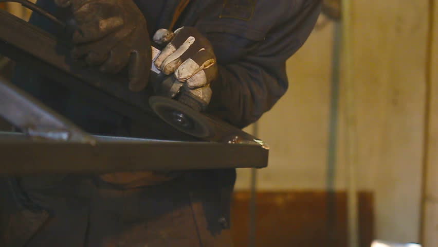 Worker grinding metal construction with a circular saw