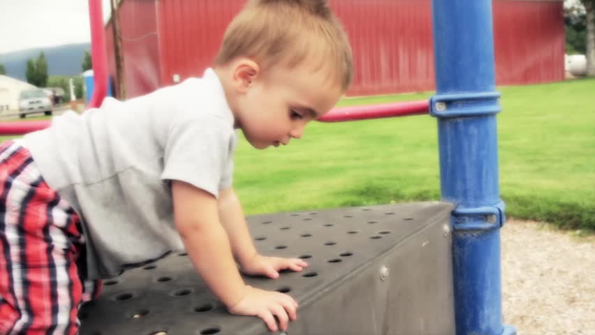 A mother watches her toddler at the park