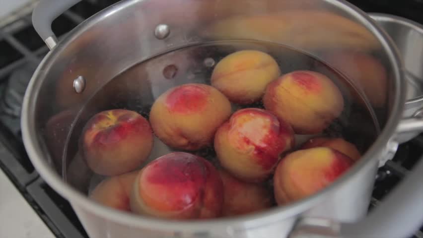 Boiling peaches to can them for food storage