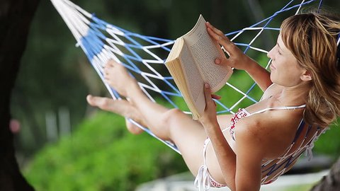 Young lady reading a book in hammock. Loopable