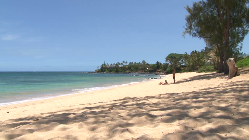 Couple enjoying peaceful sandy beach in Maui, Hawaii.