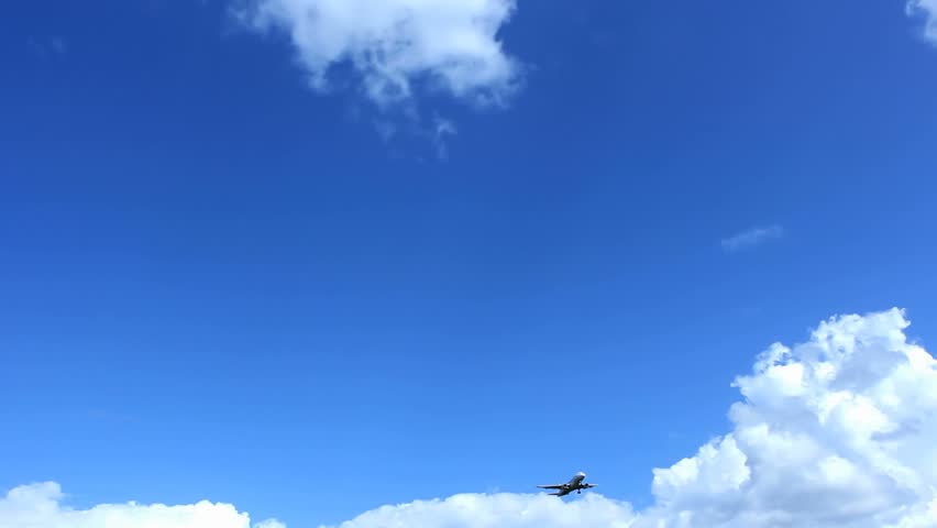 Passenger airplane landing approach across a cloudy sky. Copy-space.