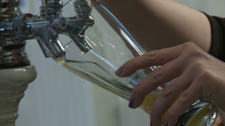 Close up on beer being poured from a tap.