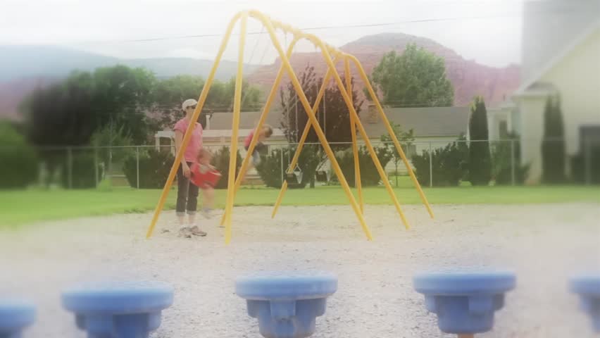 A family playing on the swings at the park