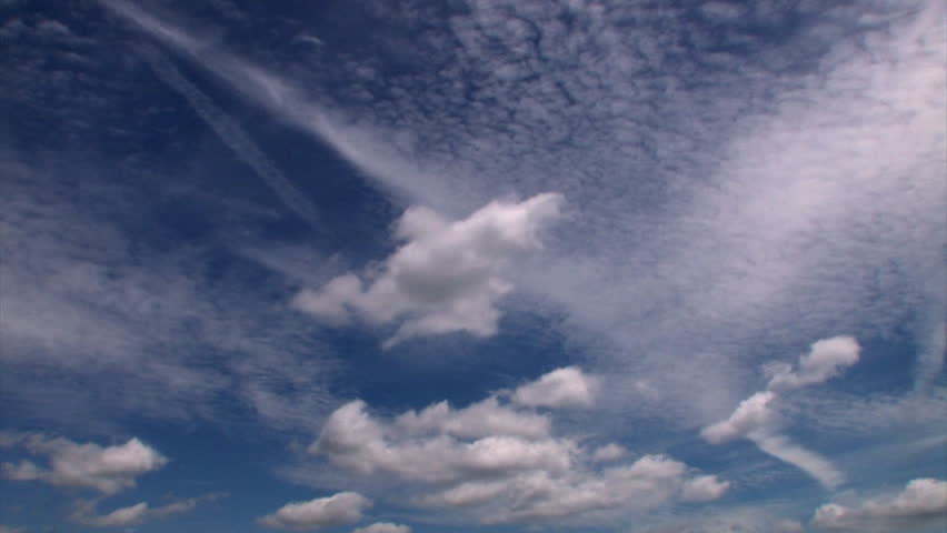 Time lapse of white puffy clouds in a deep blue sky.