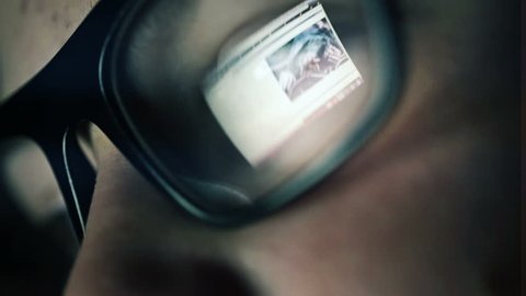Closeup shot of boy in glasses surfing internet at night
 Video Stok