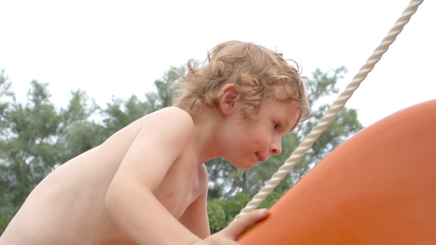 Slow Motion Shot Of A Young Boy Skilfully Climbing Up The Slide