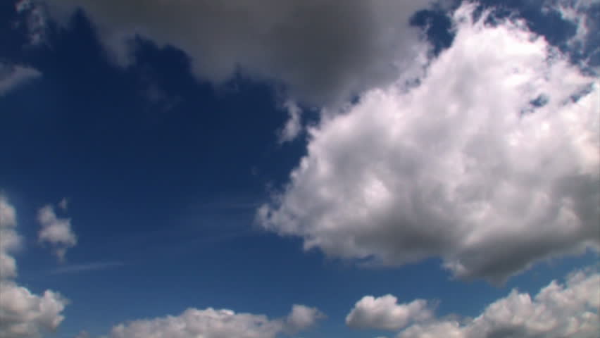 Time lapse of white puffy clouds in a deep blue sky.