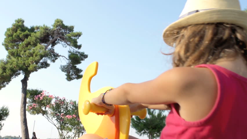 Slow Motion Shot Of A Young Girl With Long Hair Wearing A Hat Riding A