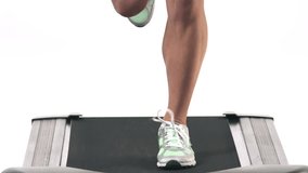 Close up shot of a female running in place on a treadmill, while looking into the camera on a white background